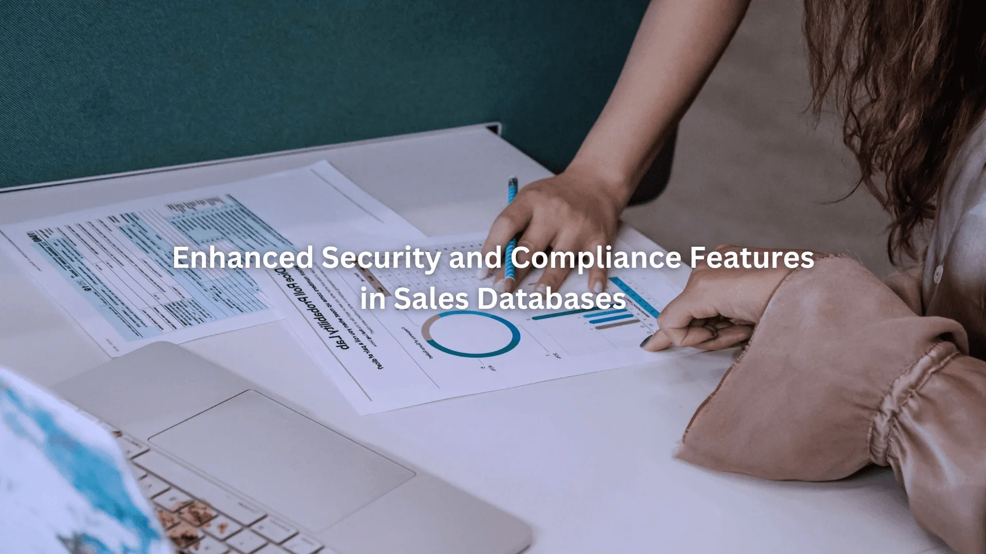 Two people reviewing charts and documents at a desk with a laptop, focusing on GDPR compliant sales database analysis and compliance.