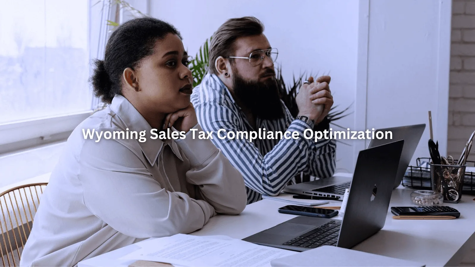 Two professionals attentively discussing Wyoming sales database cleanup during a focused office meeting.