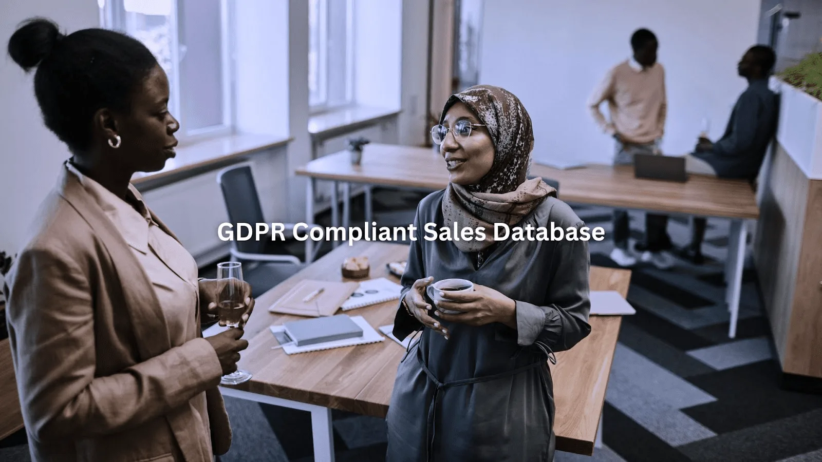Two colleagues networking and discussing ideas in an office setting, highlighting Database Management for Sales teamwork.