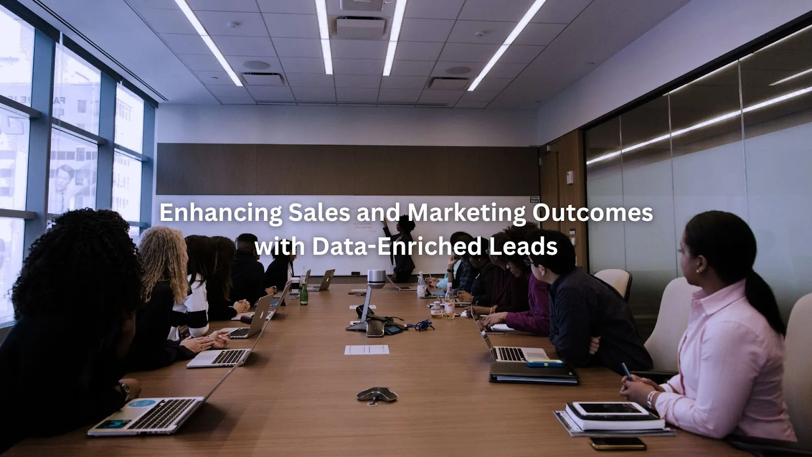 Business professionals attentively listen to a presenter, illustrating data-enriched sales and marketing strategies.